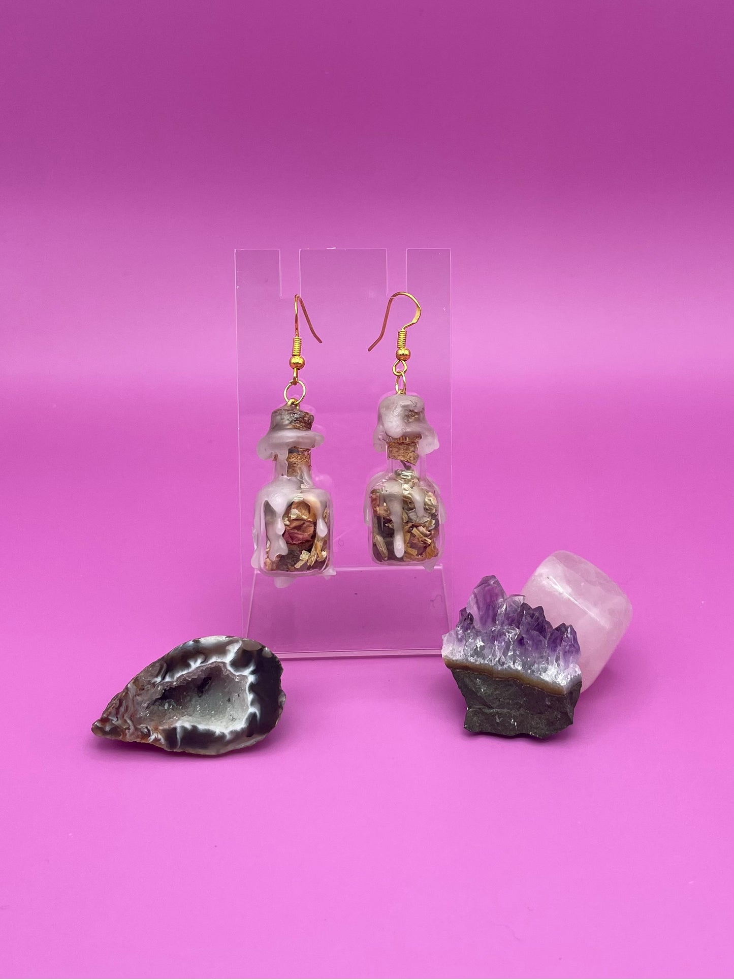Love spell jar earrings on clear stand