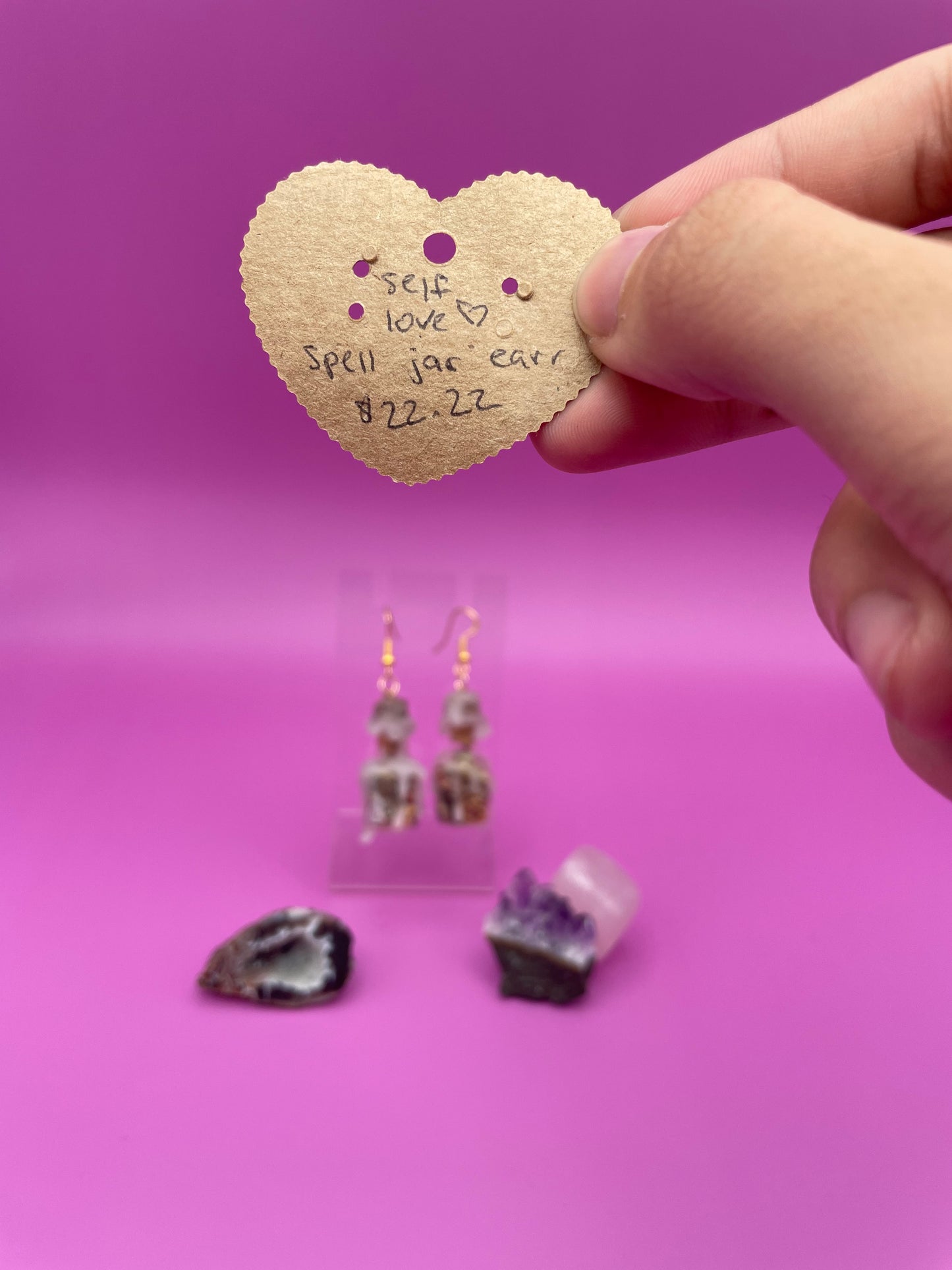Love spell jar earrings on clear stand