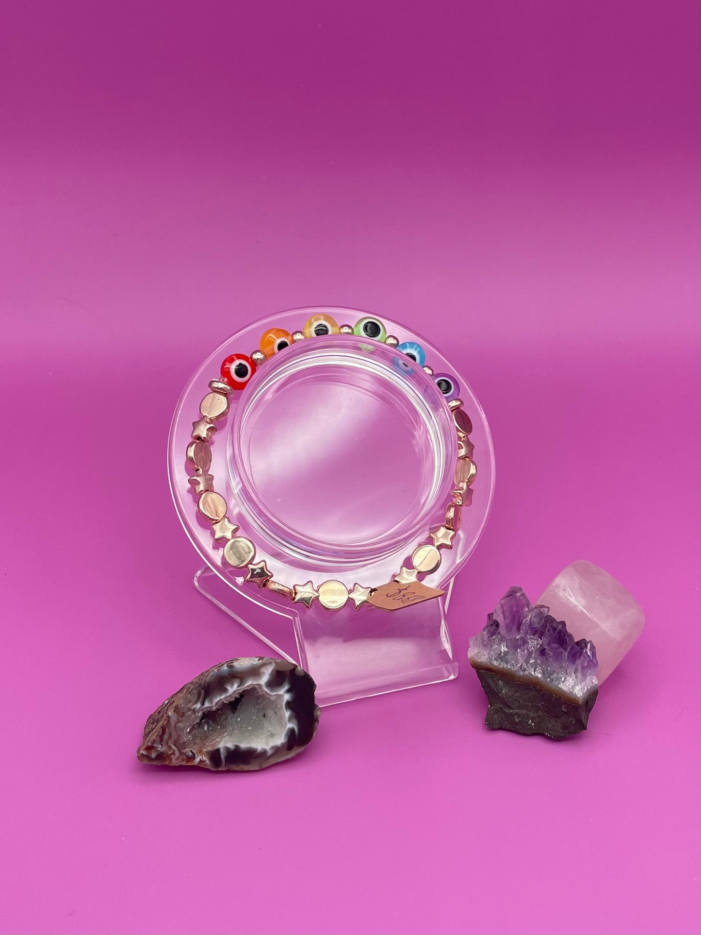 Rose Gold and rainbow evil eye bracelet on clear stand