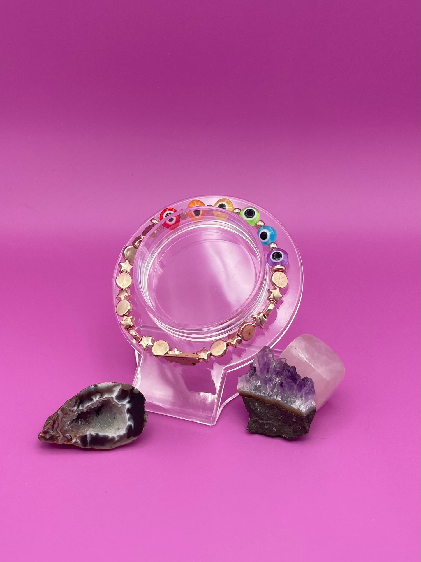 Rose Gold and rainbow evil eye bracelet on clear stand
