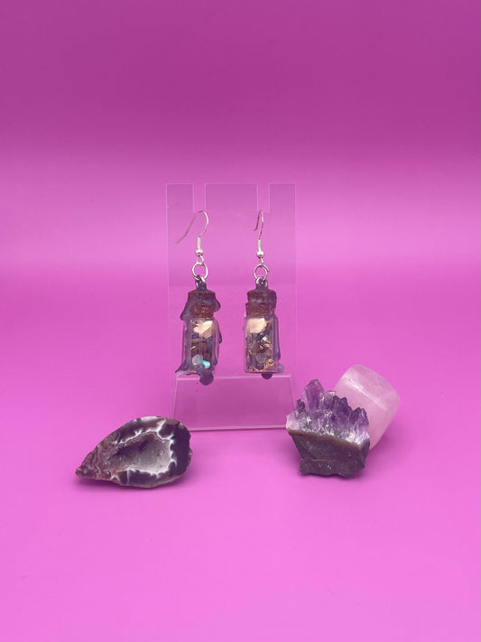 Peace spell jar earrings on clear stand