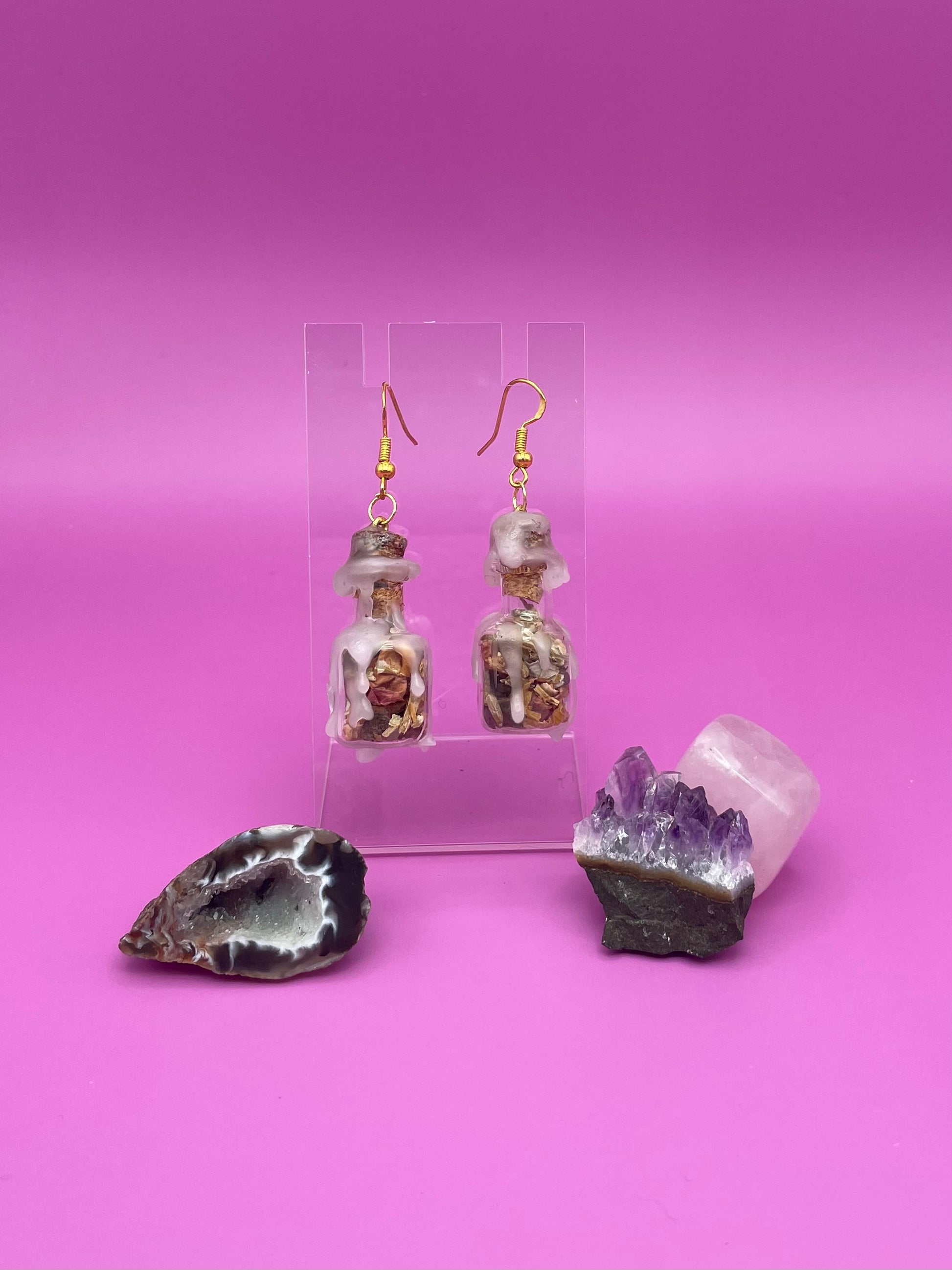 Love spell jar earrings on clear stand