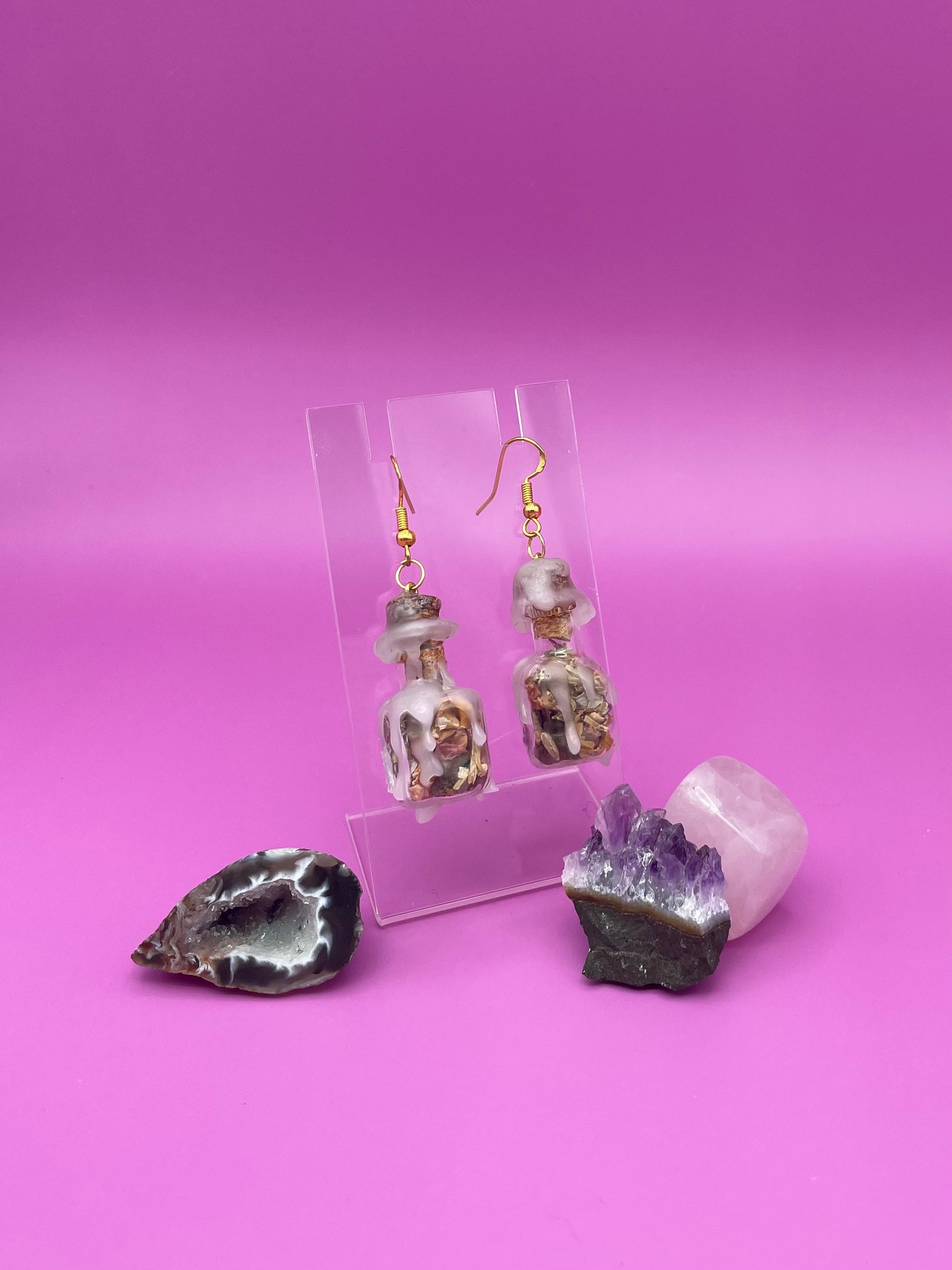 Love spell jar earrings on clear stand